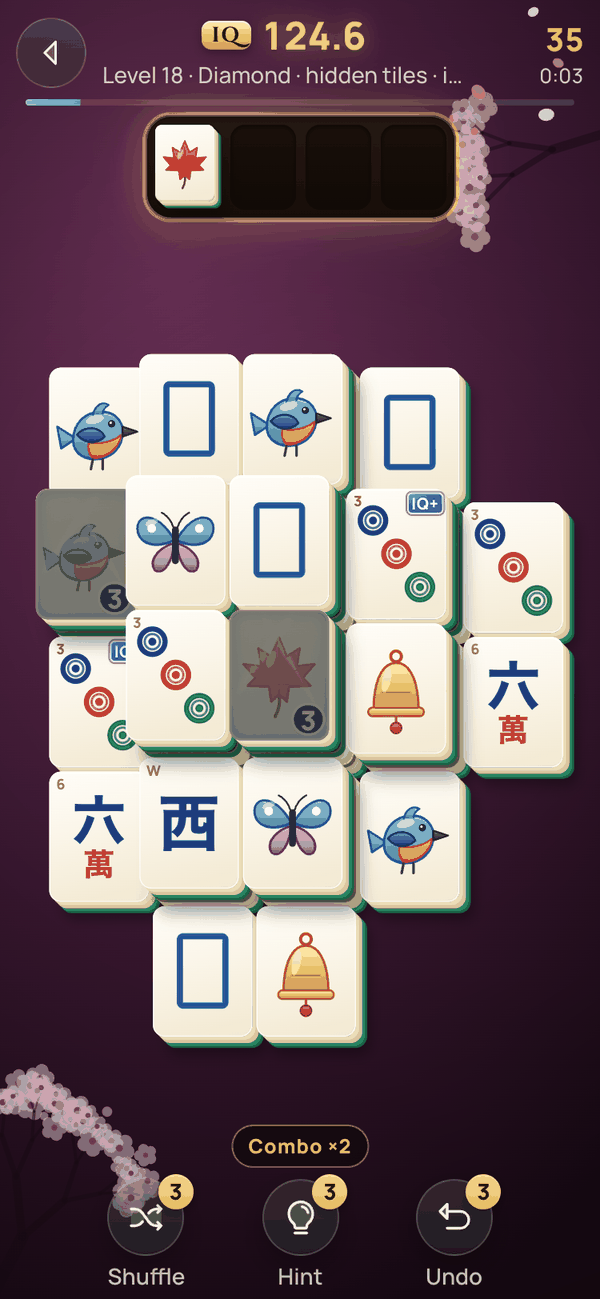 Plum Mahjong en plena partida: un rombo de grandes fichas de marfil con pájaros, mariposas, campanas y círculos, dos fichas atrapadas en el hielo, una hoja de arce esperando en la bandeja de cuatro huecos, Player IQ 124.6 y un combo de dos.